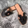HERMES ORAN SLIDE SANDALS IN BLACK SWIFT PERFORATED CALFSKIN - HMSD101
